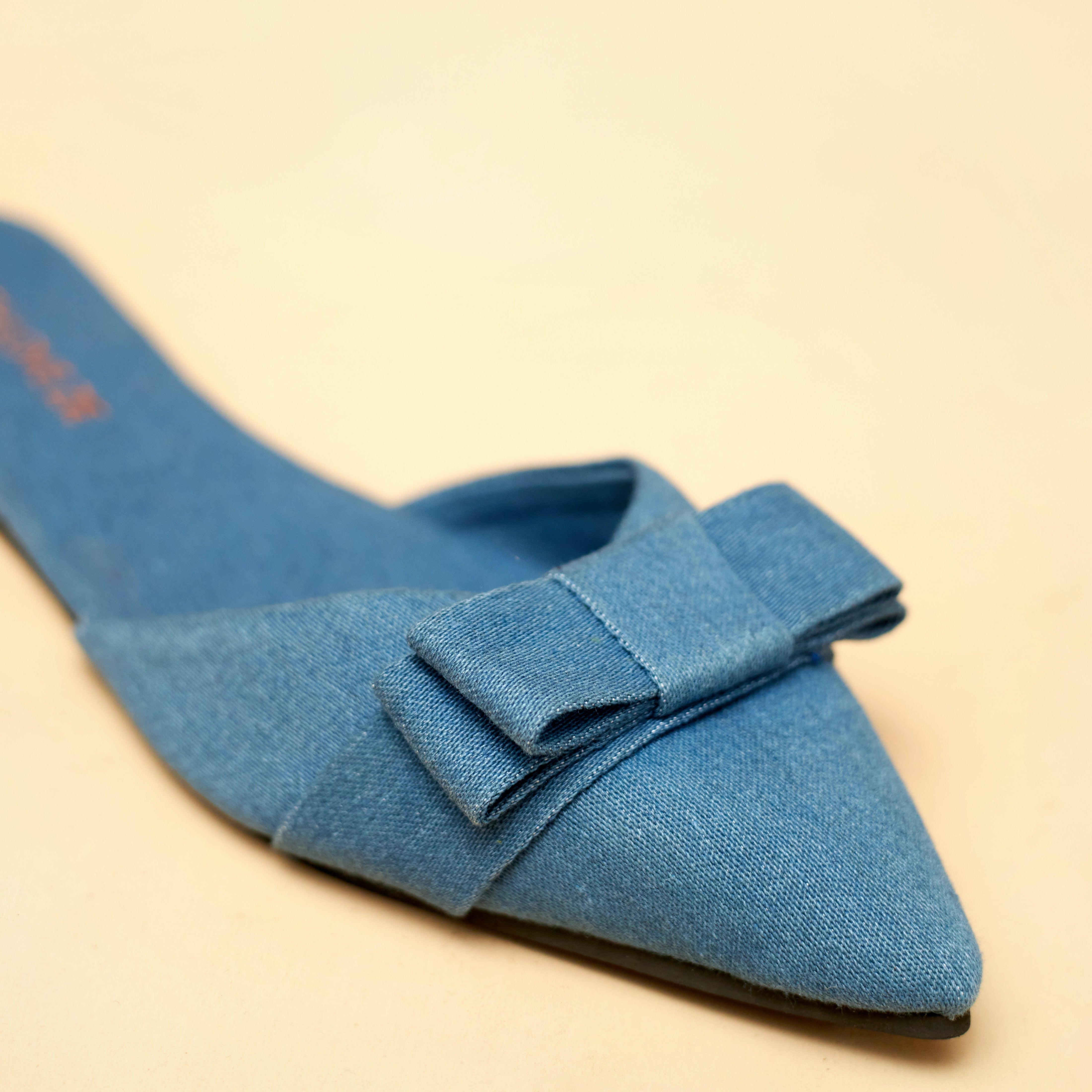 Denim shoe with a bow on a beige background